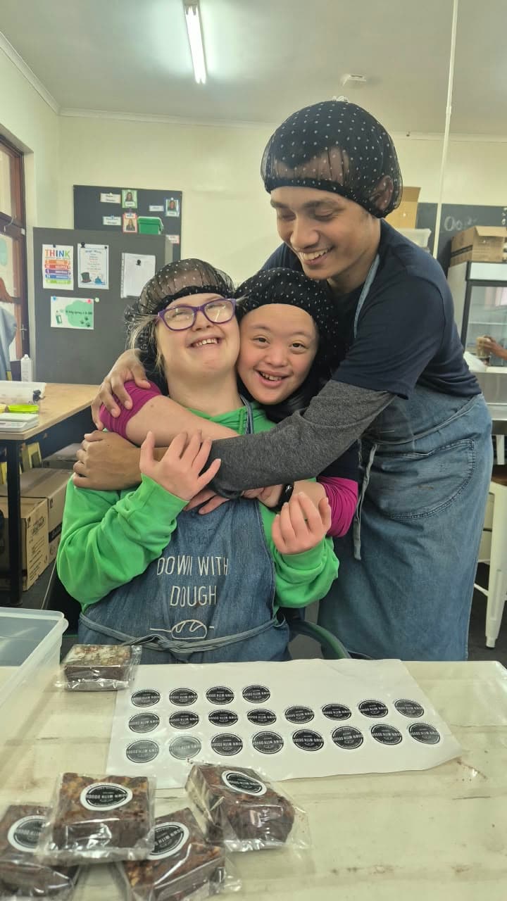 Three Down With Dough bakers sharing a hug